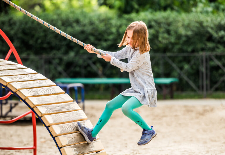 Child climbing with rope on playground